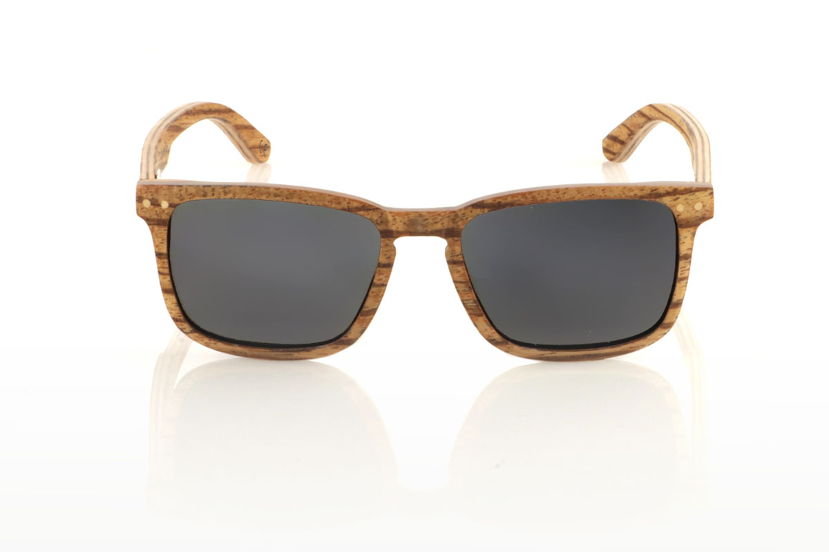 Wood eyewear of Zebrano ROMUALD. ROMUALD wooden sunglasses stand out for their design, entirely made of light-colored laminated zebrawood with a marked grain, which gives them a distinctive and natural presence. Its more square shape adapts perfectly to smaller faces, offering a balanced and attractive aesthetic. Round maple wood inlays on the front add delicate detail. With measurements of 135x41 and a caliber of 50, these glasses are ideal for those looking for an accessory with personality and style. for Wholesale & Retail | Root Sunglasses® 
